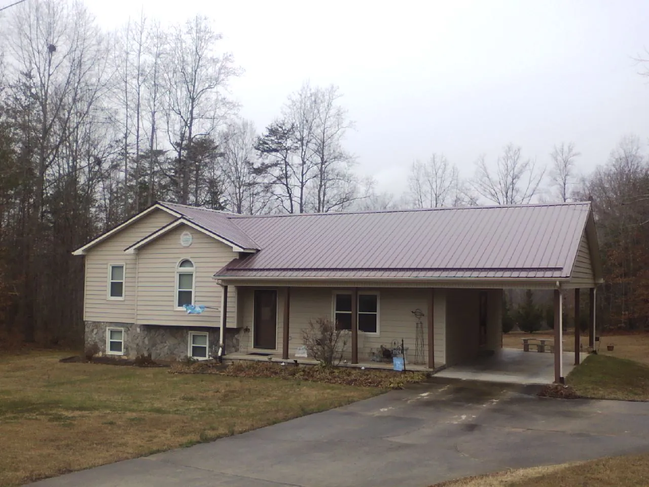 Burgundy metal roof on a tan split level home with an attached carport in Marcus Hook