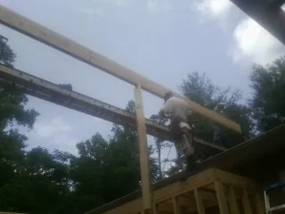 Carpenter setting a ridge beam over a new addition frame — Ice Dam Removal by Roofing Brothers in Marcus Hook