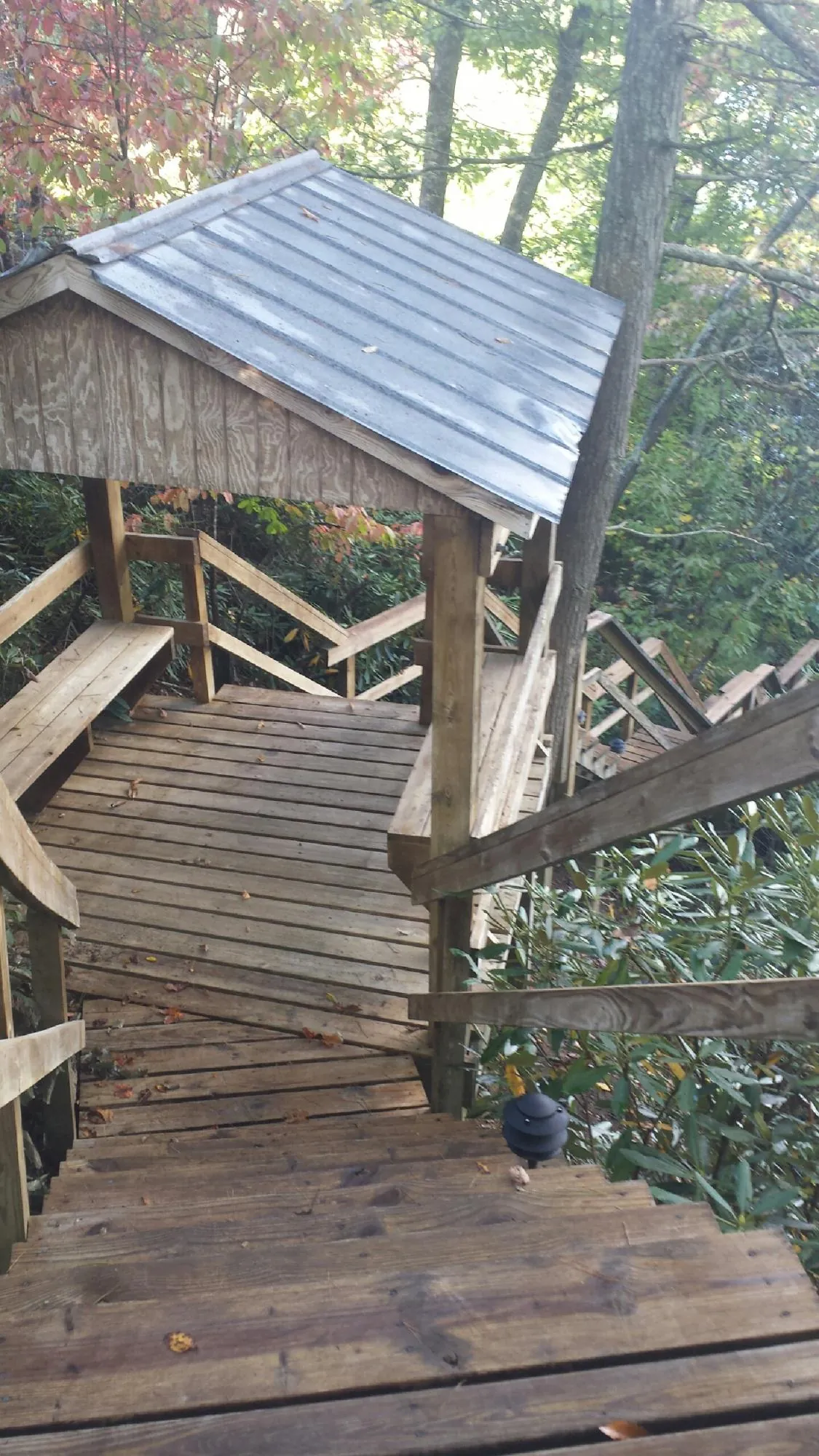 Metal roofed shelter over wooden steps on a wooded walkway — Skylight Repair & Installation work by our crew in Marcus Hook